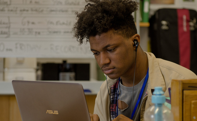 Young man composing on laptop