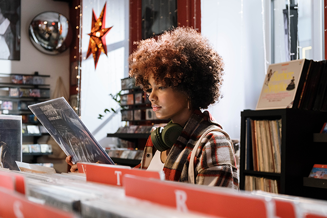 A Person in a record store looking at a record.